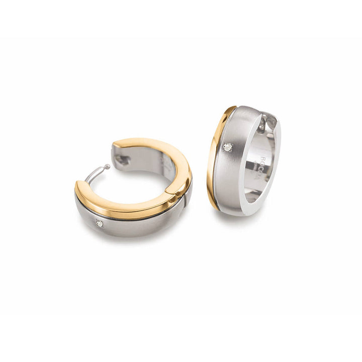 De Boccia Titanium Oorringen Bicolor 0539-20 zijn uitgevoerd in twee kleuren: geborsteld zilver en gepolijst goud. Beide zijn bezet met een sprankelend diamantje; de ene oorbel staat rechtop en de andere ligt plat.