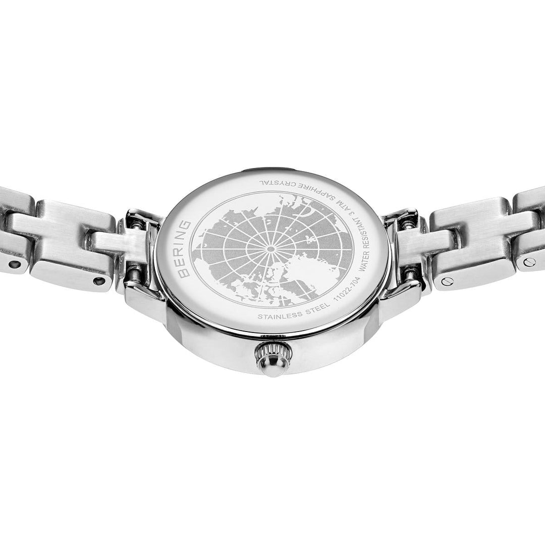 De afbeelding toont de achterkant van een Bering 11022-704 horloge, met de nadruk op de roestvrijstalen band. Een ingewikkelde kaartgravure vult de Quartz-technologie tekst en waterbestendigheidsdetails aan, waarbij de gekoppelde band de verfijnde esthetiek van het uurwerk versterkt.