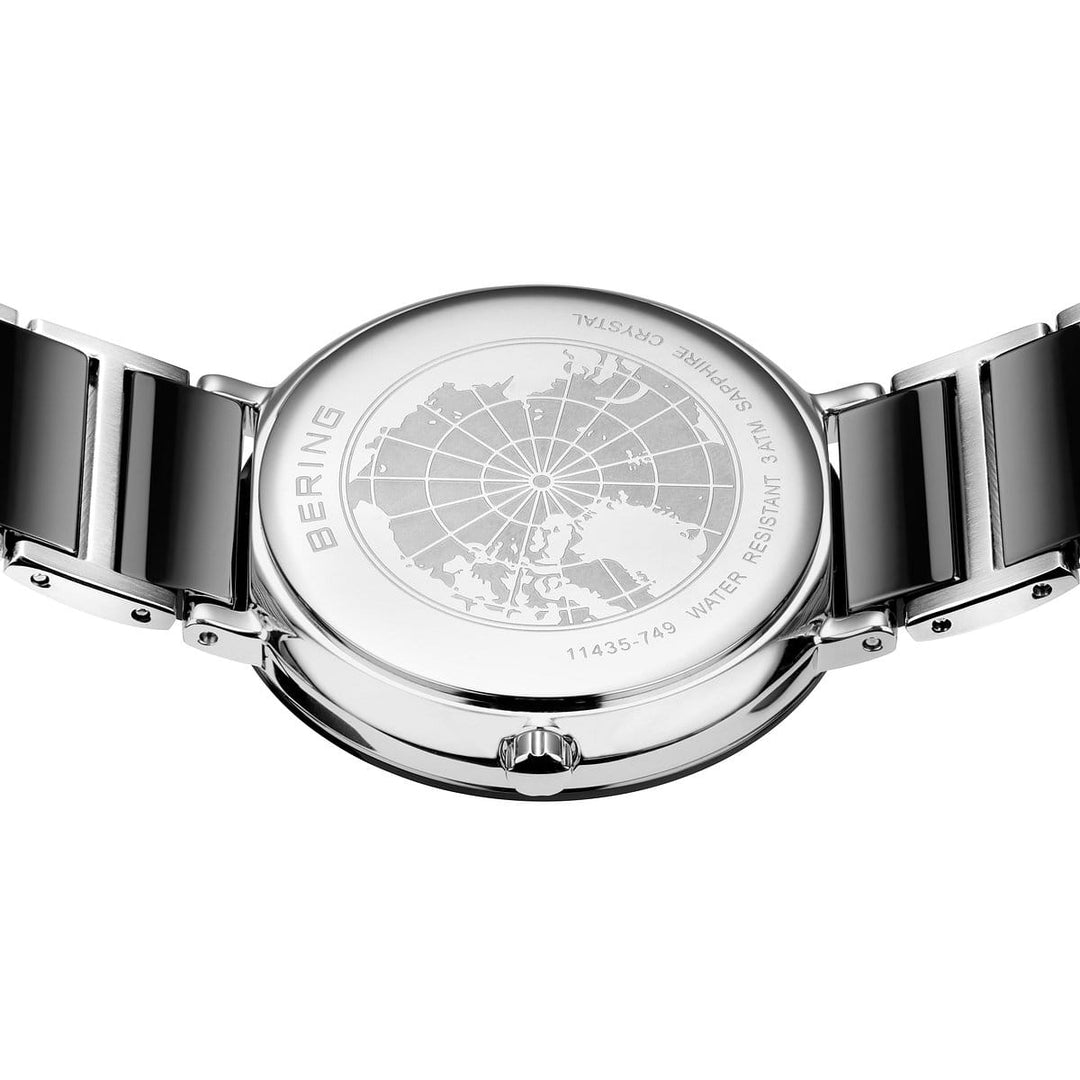De achterkant van het Bering 11435-749 Dameshorloge met metalen band heeft een gegraveerde wereldkaart en tekst die de waterbestendigheid beschrijft, terwijl Saffierglas duurzaamheid garandeert. Het horloge brengt stijl en functie op elegante wijze in evenwicht, met Bering fijn gegraveerd langs de rand.