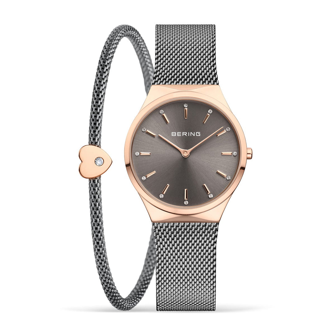 Het Bering 12131-339-GWP Dameshorloge heeft een strakke grijze Milanees band en roségouden kast, gecombineerd met een bijpassende mesh-armband met een hartvormige bedel. De donkere wijzerplaat heeft minimalistische markeringen, aangestuurd door nauwkeurig quartz-uurwerk.