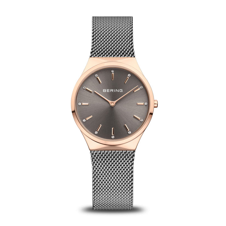 Ontdek de elegantie van Berings 12131-369-GWP horloge, met een strakke roestvrijstalen Milanese band en minimalistisch design. De ronde wijzerplaat heeft een quartz uurwerk, grijze wijzerplaat met gouden markeringen en wijzers, omhuld door een slanke roségouden lunette. De merknaam staat gecentreerd op de wijzerplaat.