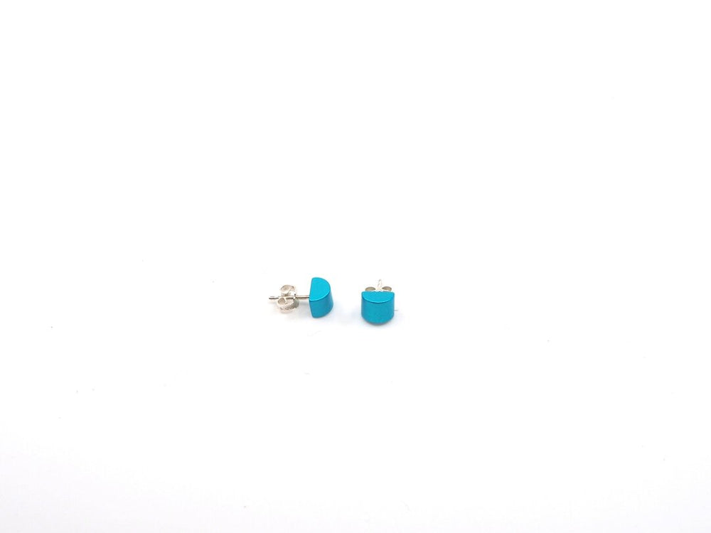 Een paar kleine, ronde turquoise oorbellen van Otra Cosa met de naam Gekleurde half ronde oorbellen turquoise zijn gemaakt van geanodiseerd aluminium met zilveren achterkanten, afgebeeld op een effen witte achtergrond.