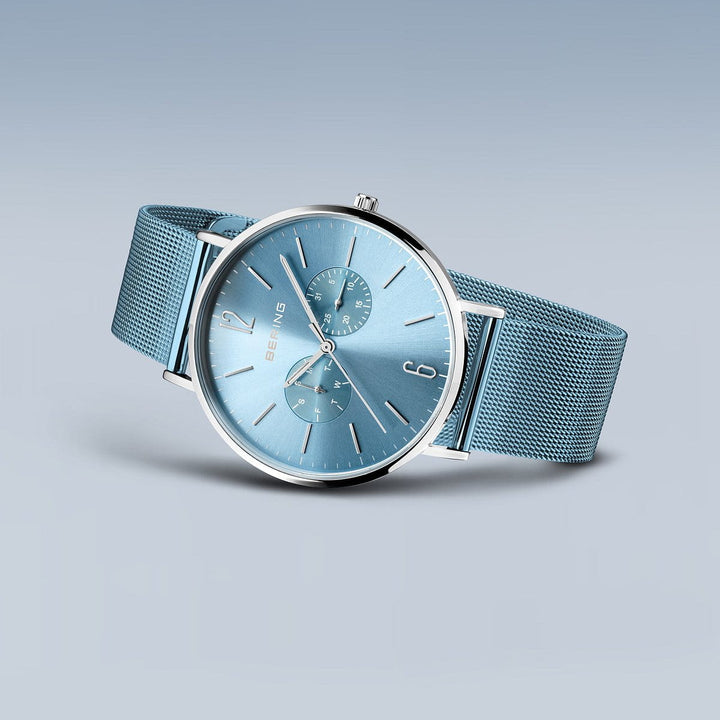 De Bering 14240-809 Herenhorloge is een stijlvol horloge met een blauwe wijzerplaat met een mesh band en zilveren accenten. De roestvrijstalen kast omlijst de wijzerplaat, met twee subdials en strakke uurmarkeringen op een gradiëntblauwe achtergrond.