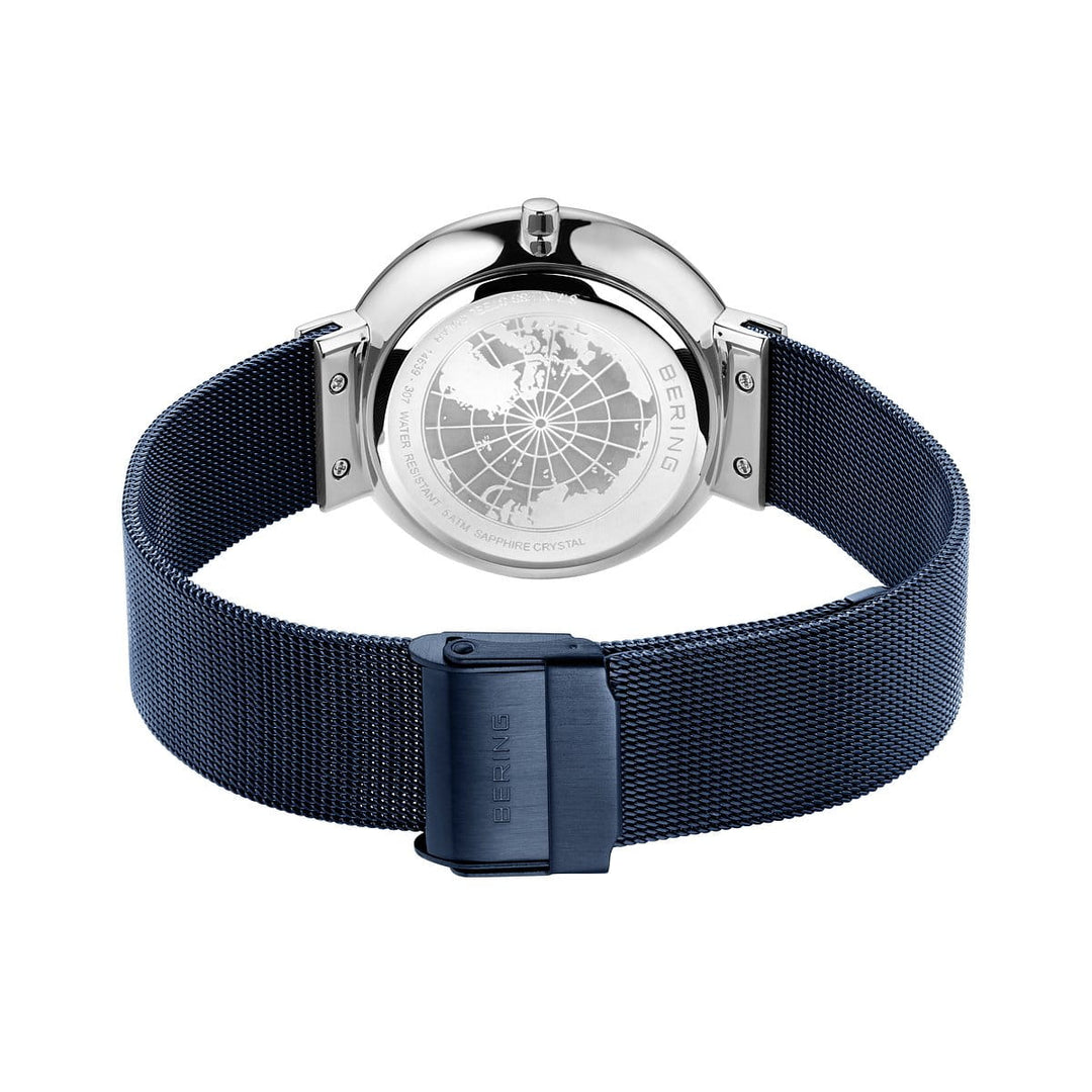 De afbeelding toont een Bering horloge, model 14639-307, met een blauwe mesh band en saffierglas. De achterkant van de kast heeft een gegraveerd wereldbolontwerp en de merknaam, terwijl de sluiting het iconische Bering logo toont.