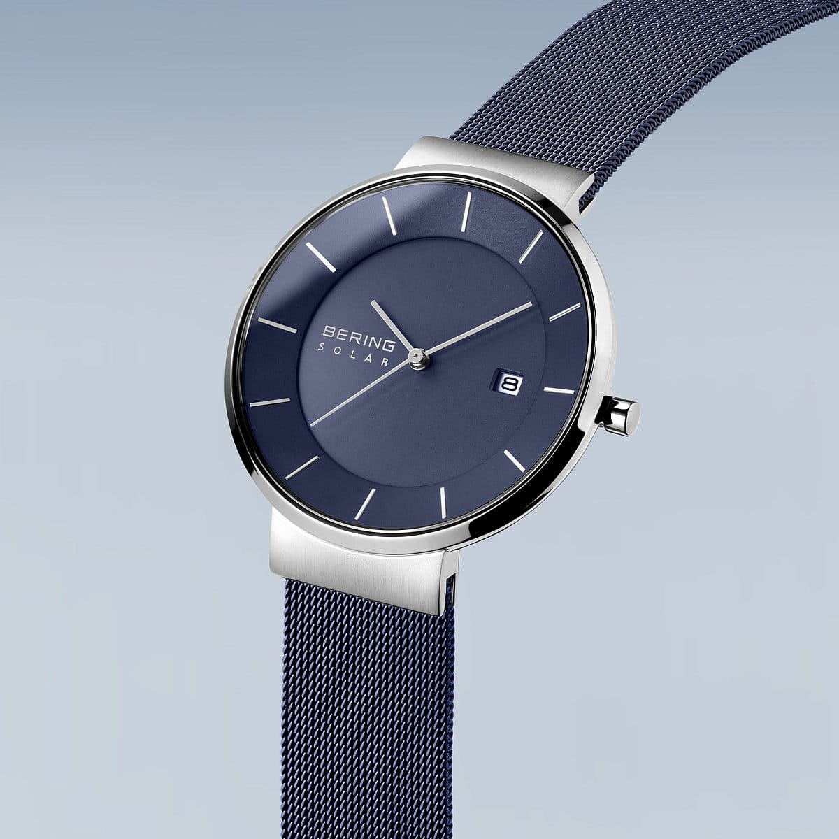 Het Bering 14639-307 Herenhorloge heeft een strak design met een zilveren kast, mesh band en een lichtblauwe wijzerplaat met kleurverloop. Dit solar-uurwerk heeft minimalistische uurmarkeringen, Bering Solar-tekst op de wijzerplaat, een datumvenster op drie uur en wordt beschermd door duurzaam saffierglas.