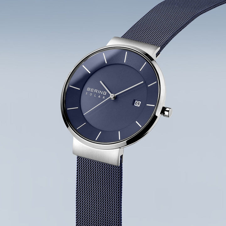 Het Bering 14639-307 Herenhorloge heeft een strak design met een zilveren kast, mesh band en een lichtblauwe wijzerplaat met kleurverloop. Dit solar-uurwerk heeft minimalistische uurmarkeringen, Bering Solar-tekst op de wijzerplaat, een datumvenster op drie uur en wordt beschermd door duurzaam saffierglas.