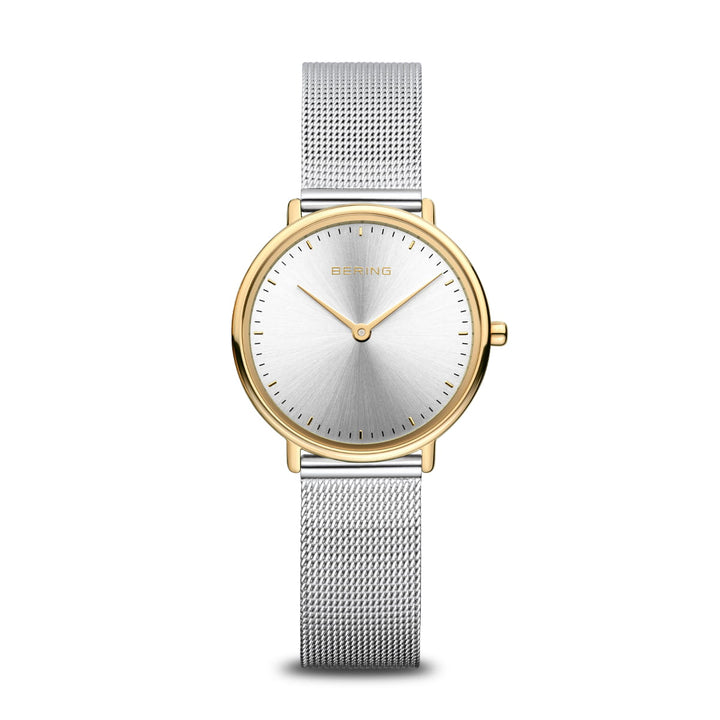 De Bering 15729-010 is een strak dameshorloge met een minimalistisch design, met een gouden lunette en zilveren wijzerplaat. Het heeft een roestvrijstalen kast en mesh metalen band, eenvoudige uur- en minutenwijzers zonder cijfers, en de merknaam elegant gecentreerd. Powered by Quartz-technologie.