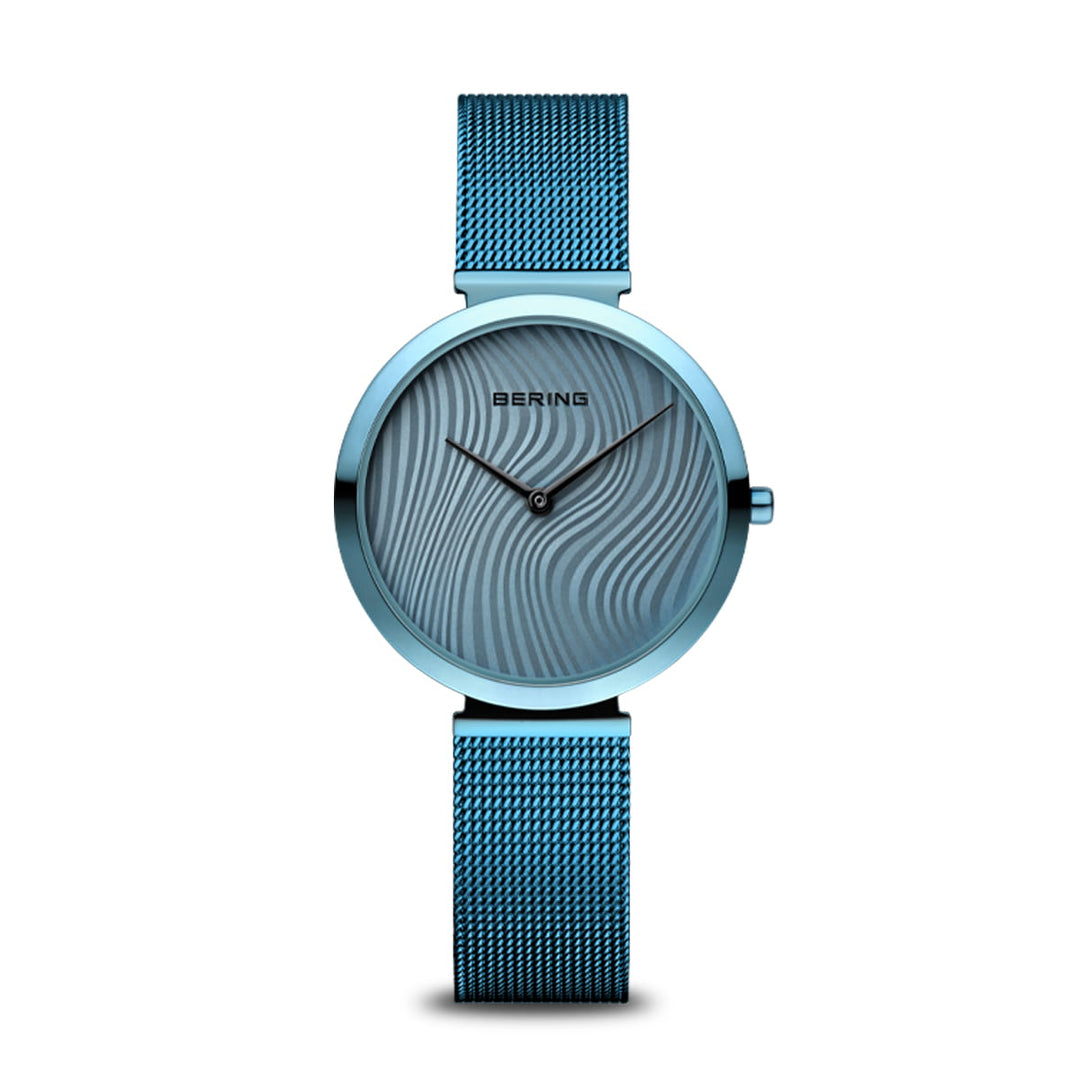 De Bering dameshorloge 18132-Charity2 heeft een blauwe wijzerplaat met subtiele golvende patronen, een mesh band, saffierglas, quartz uurwerk en eenvoudige zwarte wijzers zonder uurmarkering.