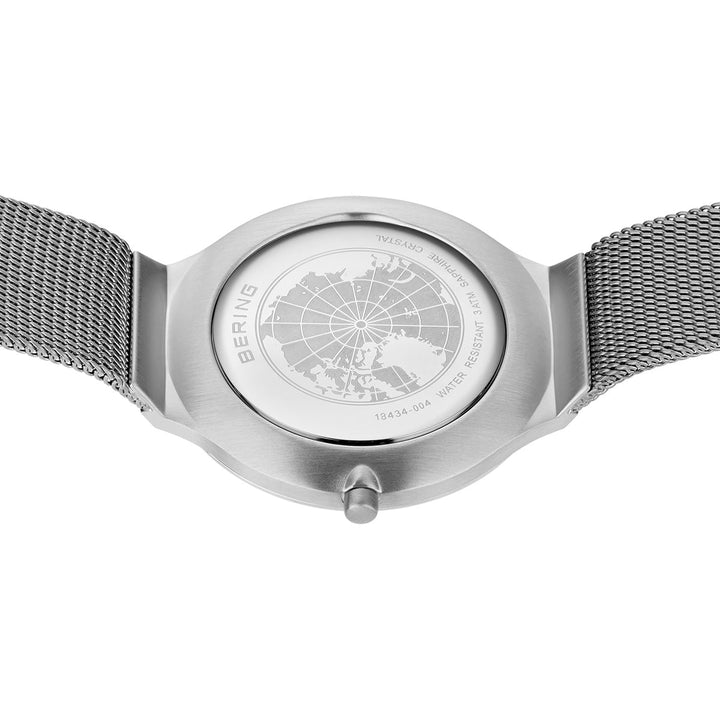 Achteraanzicht van het Bering dameshorloge (18434-004) met een zilveren meshband, voorzien van een quartz uurwerk en saffierglas. De kast is gegraveerd met een kaart, gemerkt met BERING en specificaties voor waterbestendigheid en roestvrij staal materiaal.