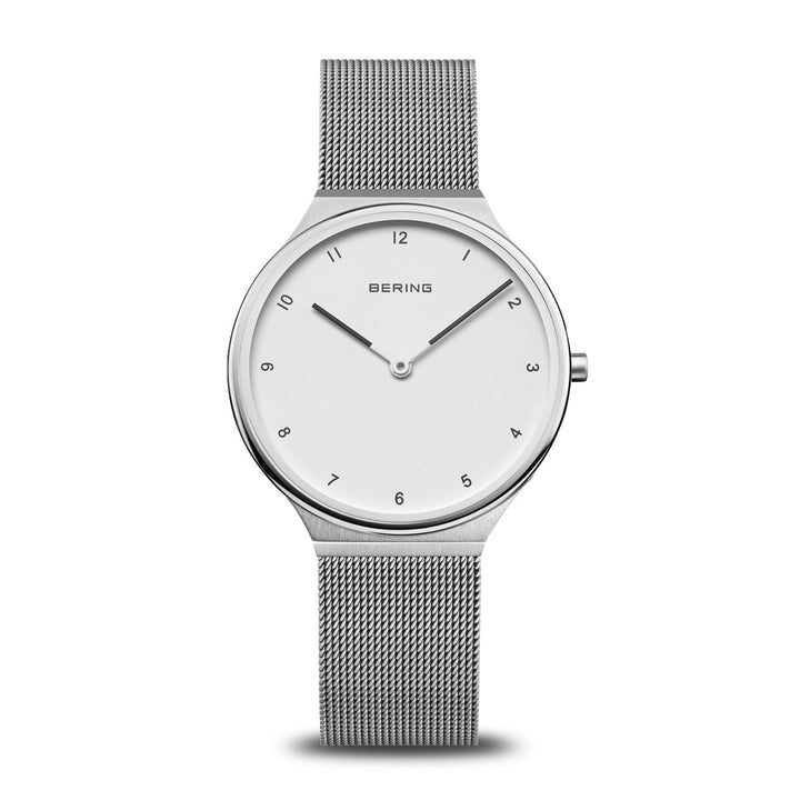 Het Bering dameshorloge 18434-004 heeft een minimalistisch ontwerp met een zilveren meshband en een witte wijzerplaat, met zwarte uurmarkeringen en wijzers, het BERING-logo bovenaan in het midden. Het beschikt over een quartz-uurwerk en krasbestendig saffierglas, wat elegantie in eenvoud biedt.