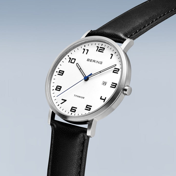 Het Bering heren horloge model 18640-404 heeft een minimalistische witte wijzerplaat met zwarte cijfers in een strakke zilveren kast. Het heeft zwarte uur- en minutenwijzers, een blauwe secondewijzer en een datumvenster op 3 uur. Aangedreven door Quartz-uurwerk, wordt het aangevuld met een zwarte leren band.