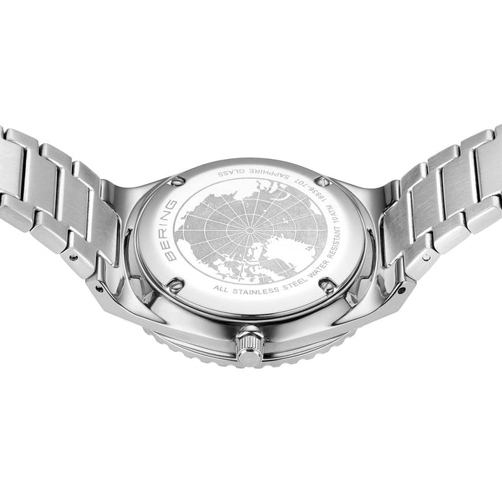 De afbeelding toont de achterkant van een Bering dameshorloge van roestvrij staal met een gegraveerde wereldkaart, voorzien van een metalen schakelband, saffierglas en een waterdichtheid van 10 ATM. Dit elegante horloge is model 18936-707 met een blauwe wijzerplaat.