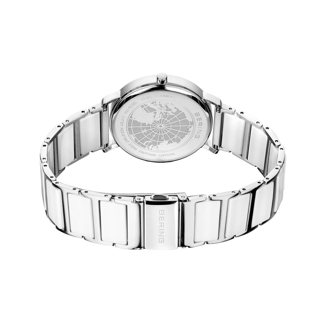 Een achteraanzicht van het Bering dameshorloge (19535-754), met een zilverkleurige keramische band. De kast is versierd met een gegraveerd kaartontwerp en het merk BERING staat op zowel de kast als de sluiting.