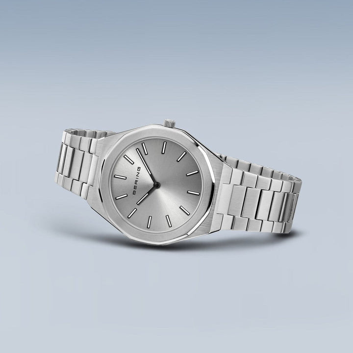 Dit Bering heren horloge (19641-700) heeft een strak design met een zilveren kast, metalen band en minimalistische ronde wijzerplaat. Dunne uurmarkeringen en wijzers worden beschermd door saffierglas, terwijl de gradiënt blauw-witte achtergrond het nauwkeurige quartzuurwerk accentueert.