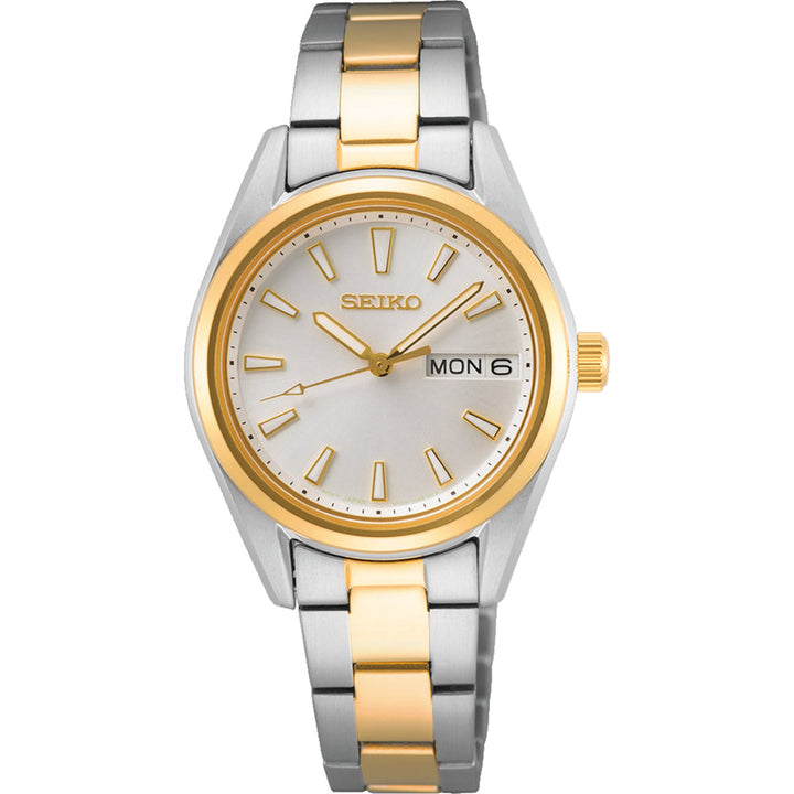 Het Seiko dameshorloge SUR454P1 heeft een ronde wijzerplaat met gouden uurmarkeringen en wijzers. Het quartz uurwerk toont Mon 6, terwijl de band zilveren en gouden schakels afwisselt, aangevuld met krasbestendig Saffierglas voor verfijning.