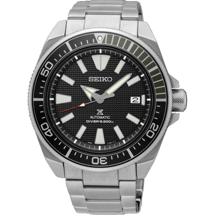 Het Seiko Prospex heren horloge SRPF03K1 is een zilveren duikhorloge met een zwarte wijzerplaat met grote witte uurmarkeringen, wijzers en datumvenster op 3 uur. Het heeft Automatic Divers 200m tekst, een lunette minutenschaal, een automatisch uurwerk en een metalen band.
