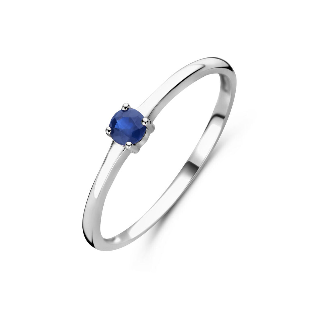 Een slanke Van der Kooij Collectie 925 zilveren ring met september geboortesteen saffier in een eenvoudige vierpoot zetting, gerhodineerd en gepresenteerd tegen een witte achtergrond.