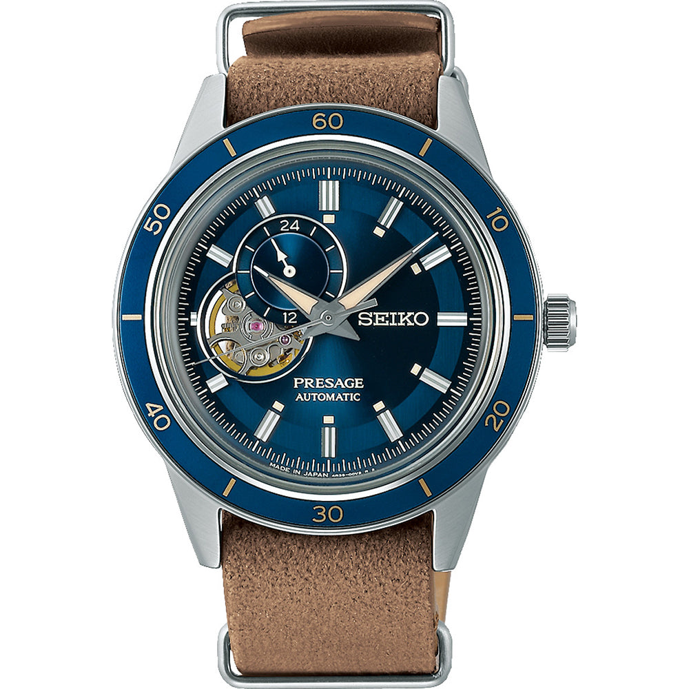 Het Seiko Presage heren horloge SSA453J1 heeft een blauwe wijzerplaat met zichtbare tandwielen, omhuld door zilverkleurig en Hardlex mineraal glas. Het omvat een bruine leren band, 24-uurs sub-dial en goud/witte markeringen met een minutenindicator bezel.