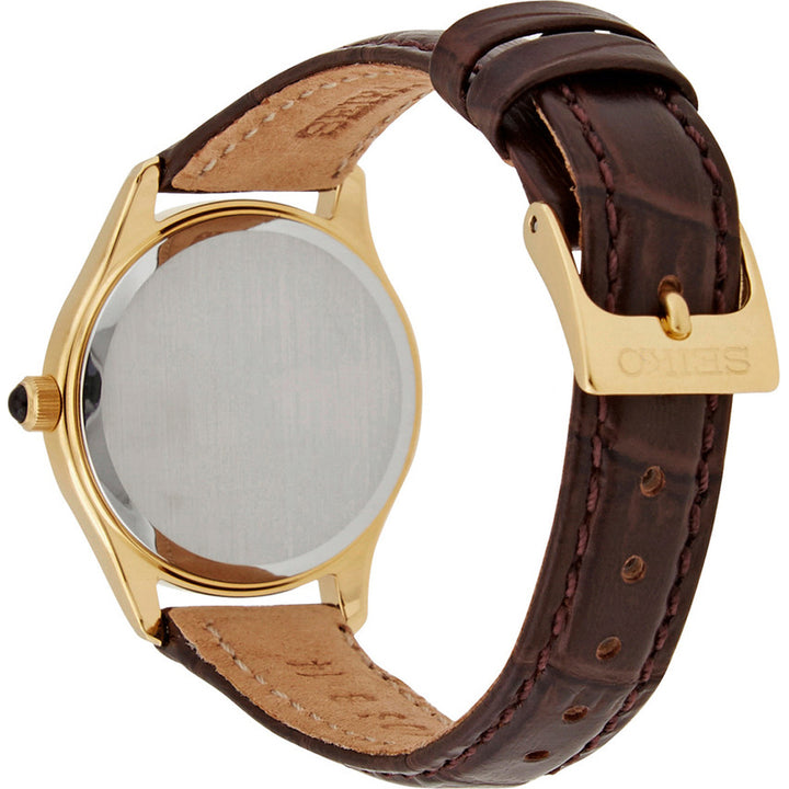 Het Seiko dameshorloge SWR072P1 heeft een goudkleurige kast, een blanco wijzerplaat, een bruine leren band en een gesp met de gravure SEIKO. Als u het horloge opzij plaatst, worden de elegante achterkant en de banddetails benadrukt met de precisie van een quartz uurwerk.