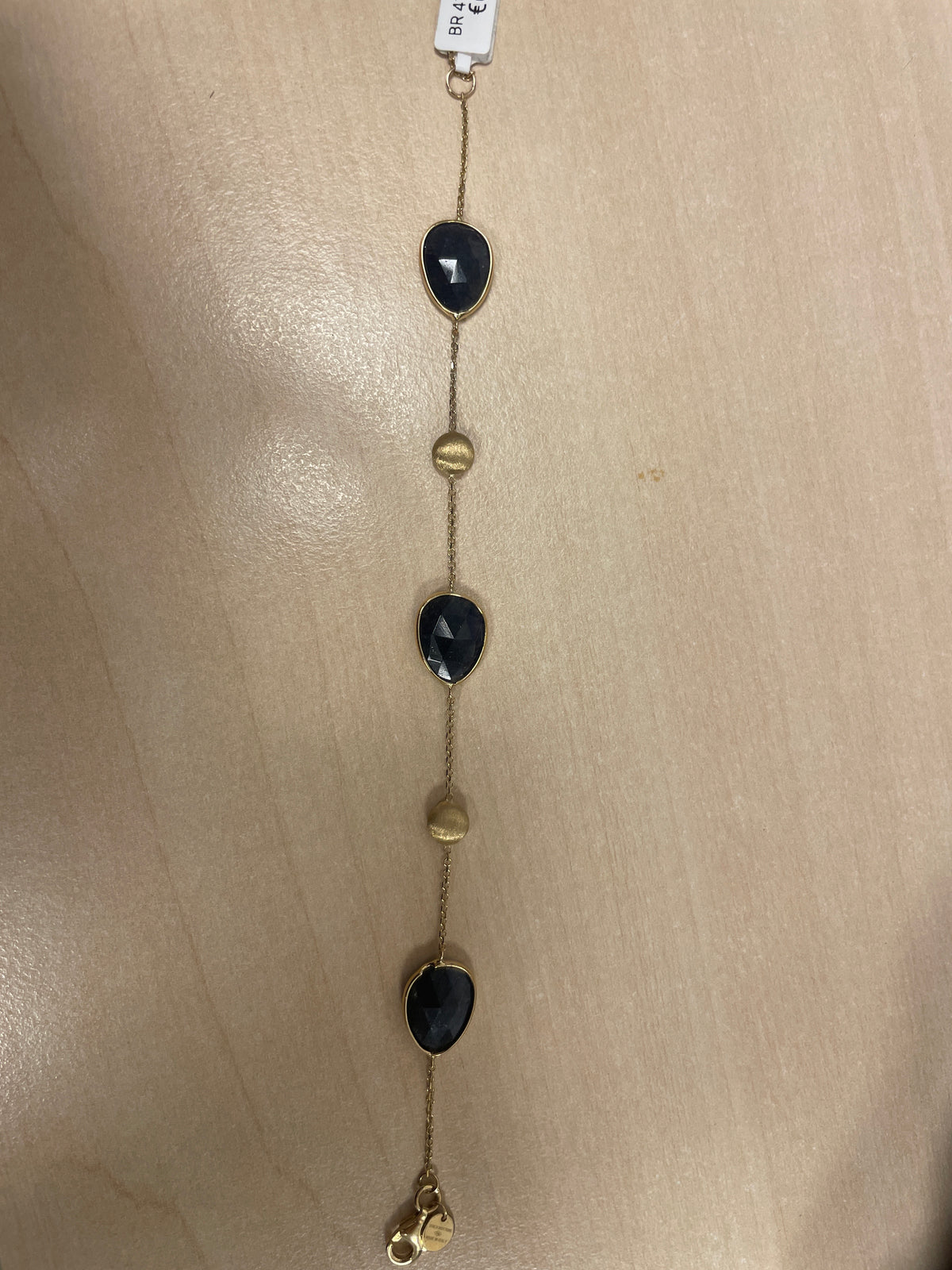Armband mit schwarzen Edelsteinen und goldenen Akzenten in schlichter Form