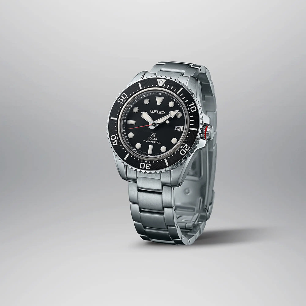 De Seiko Prospex heren horloge SNE589P1 is een strak zilveren duikhorloge met een zwarte wijzerplaat met grote witte uurmarkeringen en een datumvenster op drie uur. Het op zonne-energie werkende mechanisme en de minutenschaal op de lunette verbeteren de functionaliteit, terwijl de metalen armband elegantie uitstraalt.