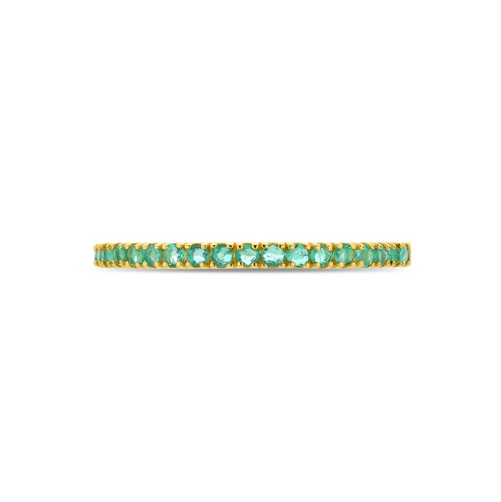 Een delicate 14K geelgouden "ring met geboortesteen smaragd mei" van de Van der Kooij Collectie, bezet met kleine smaragden in een doorlopende rij, gefotografeerd tegen een witte achtergrond.