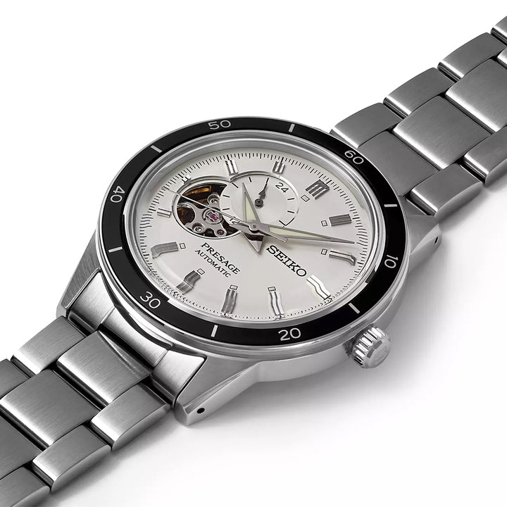 Close-up van een Seiko Presage heren horloge SSA423J1 met een roestvrijstalen kast, witte wijzerplaat, opengewerkt venster waarin het automatische uurwerk zichtbaar is, roestvrijstalen band en zwarte lunette met minutenmarkeringen.