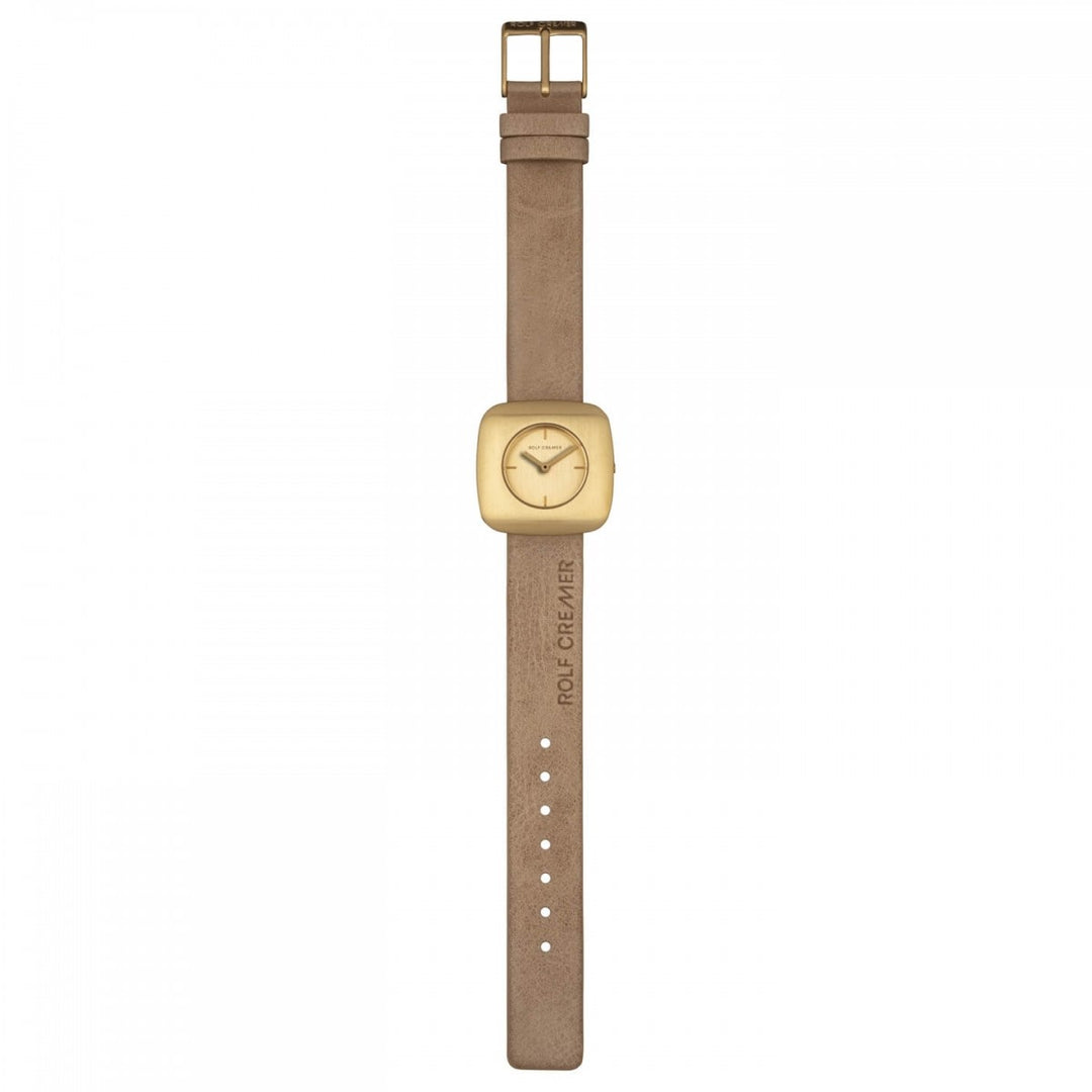 Het Rolf Cremer Horloge 508011 Edge is een quartzhorloge met een beige band en een rechthoekige, goudkleurige wijzerplaat. Het horloge heeft een minimalistisch design met verstelbare gaatjes, een ROLF CREMER-reliëf en een elegante wijzerplaat met minuten- en uurwijzers.