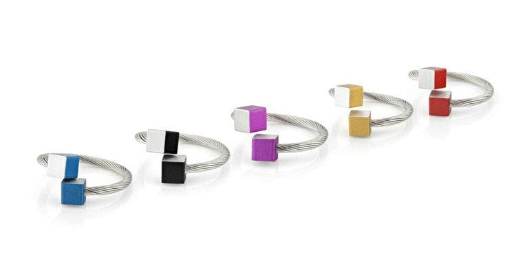 De Ring Kubusjes Zwart R4Z van CLIC Creations is een handgemaakte, verstelbare zilveren ring van chirurgisch staal met een zwarte kubus, stijlvol gepresenteerd op een witte achtergrond. Gemaakt in Nederland.