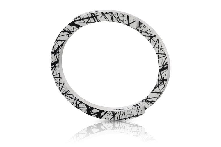 Armband aus weißem Material mit schwarzem, grafischem Muster