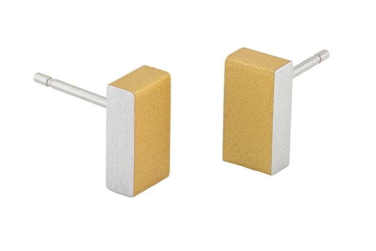 De CLIC Creations Oorsteker Rechthoekje Goud|Geel O23G heeft hypoallergene, matte, tweekleurige rechthoekige oorstekers met één gouden en één zilveren kant. Deze minimalistische oorknopoorbellen zijn rechtopstaand met zichtbare stekers voor een chique stijl.