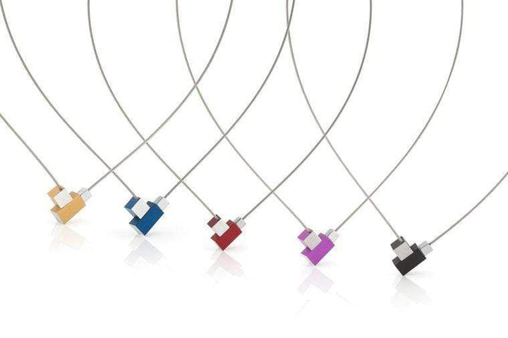 Vijf kubushangerkettingen in oranje, blauw, rood, paars en zwart zijn gerangschikt. Minimalistische hematietblokjes op edelstalen collierdraad met subtiele magnetische sluiting vormen een lichtreflecterende boog op wit. Uit de Collier Vierkantje en rechthoekje Rood C206R collectie van CLIC Creations.