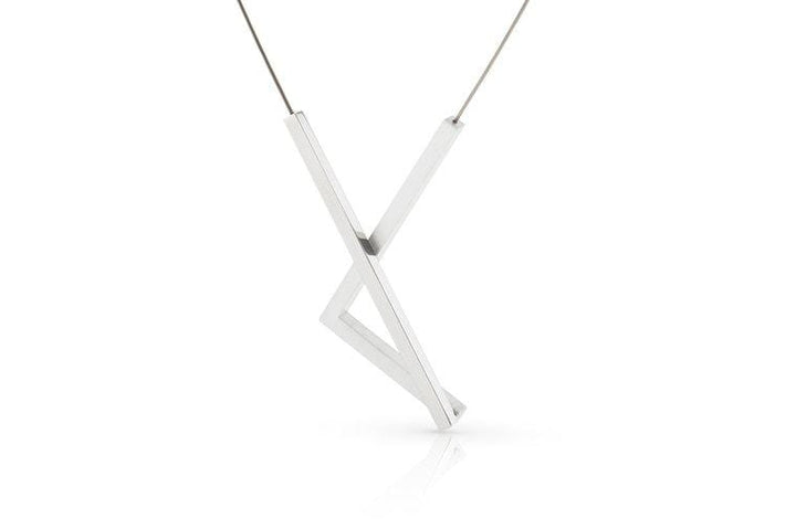 De Collier Recht en hoek C207 van CLIC Creations is een strakke, minimalistische zilveren ketting met een geometrische zigzaghanger aan een dunne ketting. Het moderne design valt op tegen een witte achtergrond en benadrukt de unieke stijl.