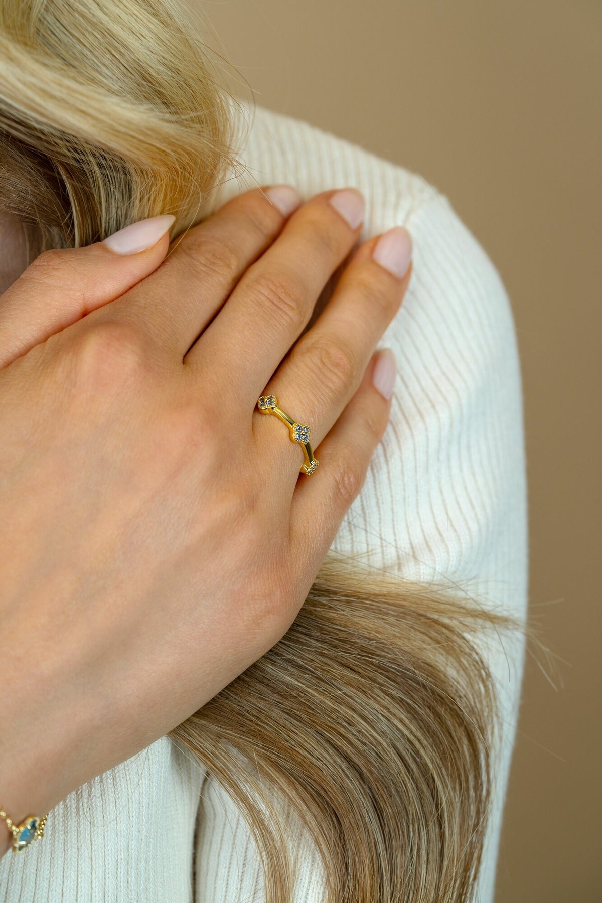 Goldplattierter Ring mit geschwungener Form und drei kleinen, funkelnden Steinen