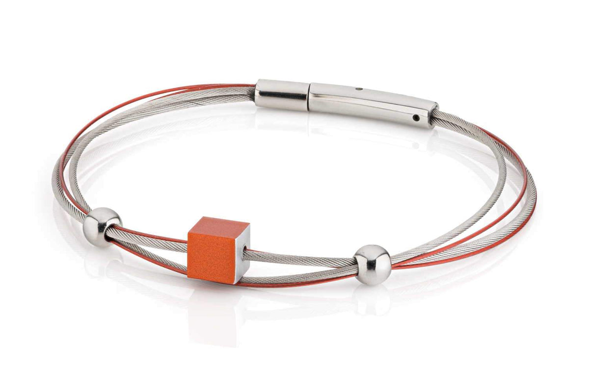 Armband mit orangefarbigem Würfel und silbernen Kugeln auf zwei Drahtsträngen
