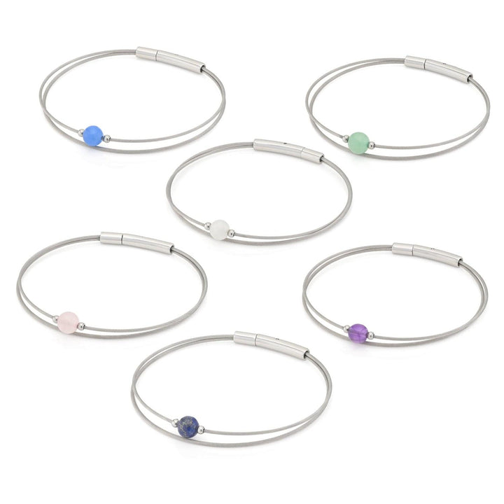 De Thinking of You Armband Maansteen A715B van CLIC Creations bevat zes zilverkleurige armbanden, elk geaccentueerd met een kraal in een andere kleur: blauw, roze, wit, groen, paars en donkerblauw. Elegant vervaardigd met edelstalen armbandelementen en gerangschikt op een ongerepte witte achtergrond.