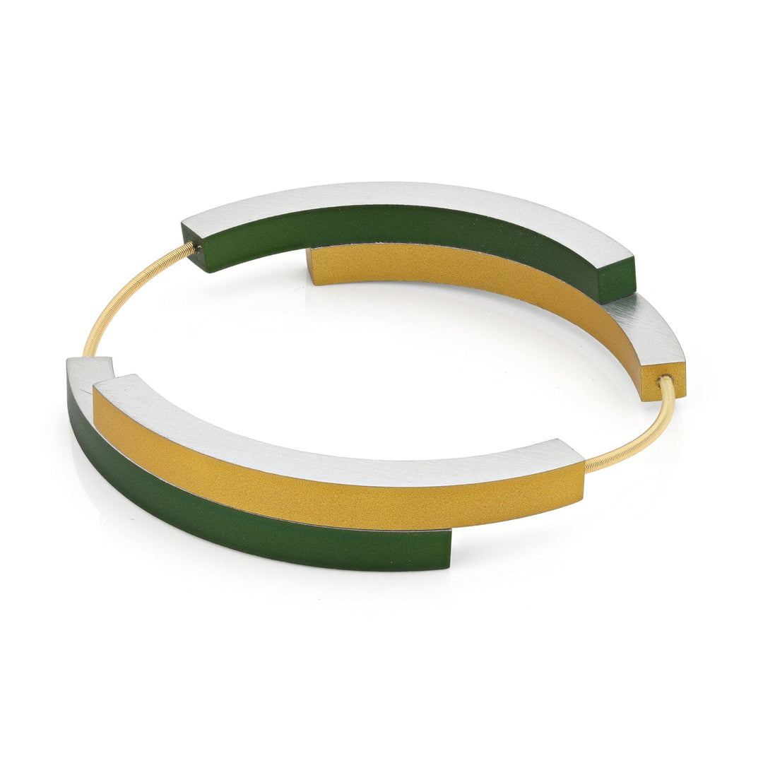 De Armband Vier bogen Groen Goud AG32GRG van CLIC Creations is een minimalistische bangle met zilveren en gouden bogen verbonden door groene accenten. Handgemaakt in Nederland, het moderne geometrische ontwerp bevat een magnetische sluiting voor een elegante, stijlvolle look.