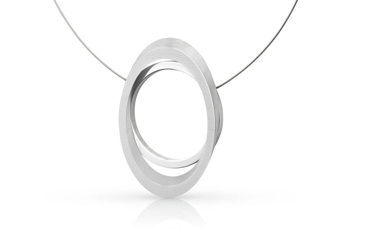 De Collier Grote ring met Ovaal C242 van CLIC Creations is een minimalistische ketting met twee in elkaar grijpende elliptische metalen ringen op een dunne draad. Het heeft een magnetische sluiting en een reflecterend oppervlak, allemaal tegen een effen witte achtergrond.