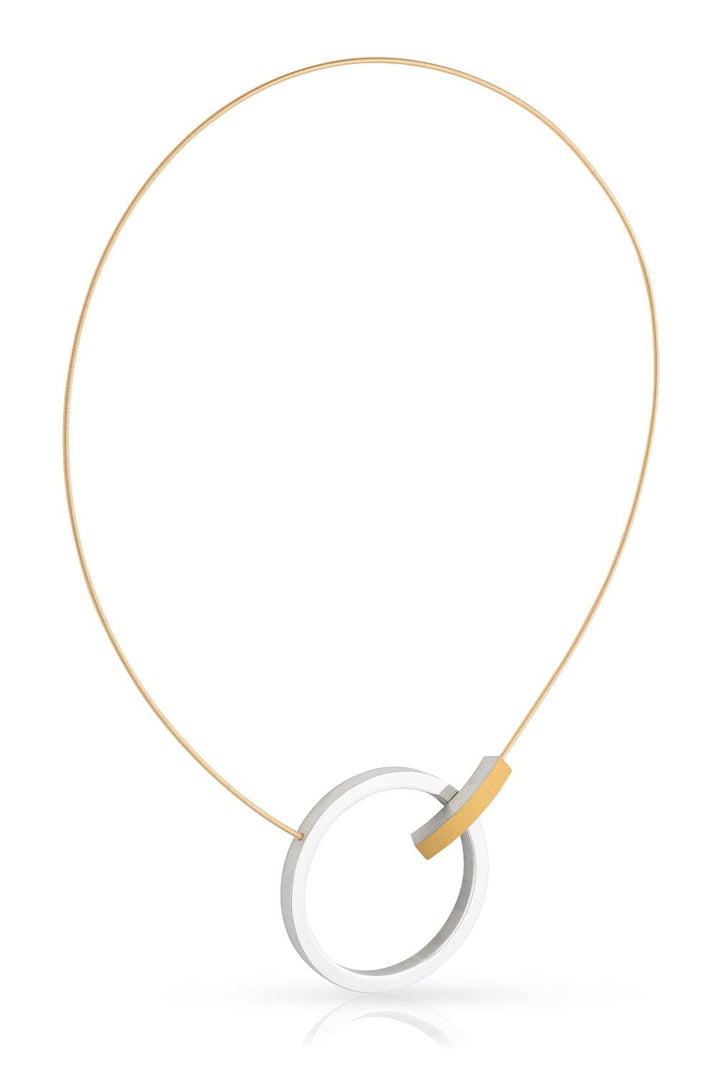 De Collier Ring met boogje C249G van CLIC Creations heeft een uniek ontwerp met een dunne gouden ketting, een grote ronde zilveren hanger die is verbonden met een kleiner gebogen gouden stuk. De minimalistische en moderne esthetiek wordt aangevuld door een magnetische sluiting, wat zorgt voor een elegante look die met de hand is gemaakt in Nederland.