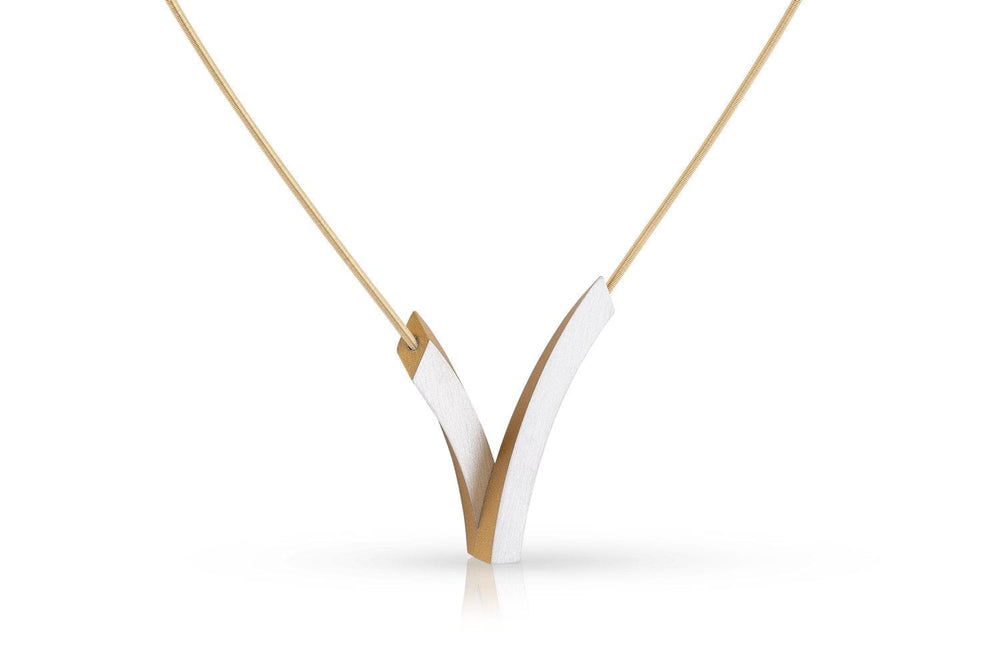 De Collier V-Bogen op elkaar Goud|Geel C255G van CLIC Creations is een minimalistische ketting met een strakke, V-vormige hanger met verweven goud- en zilvertinten. Hangend aan een dunne ketting met een magnetische sluiting, biedt het elegantie met scherpe, strakke lijnen.