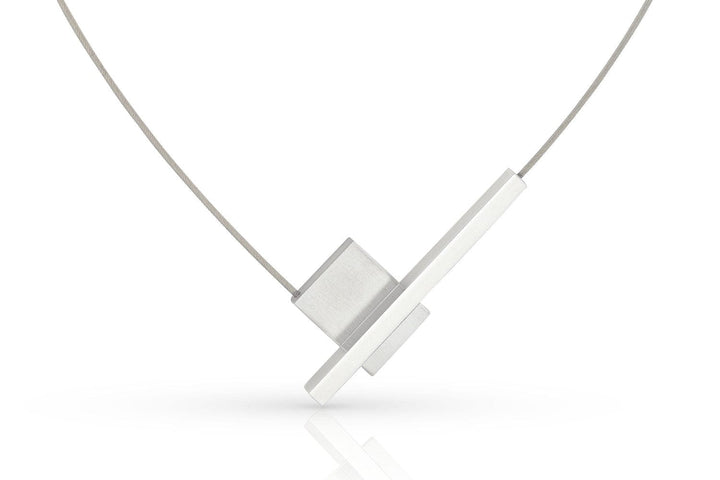 Ontdek de moderne Collier V-vorm met staafje C261 van CLIC Creations, met een uniek ontwerp met twee elkaar kruisende rechthoekige zilveren hangers aan een dunne draadketting. Handgemaakt in Nederland, voorzien van een eenvoudige magnetische sluiting, elegant gepresenteerd tegen een witte achtergrond.