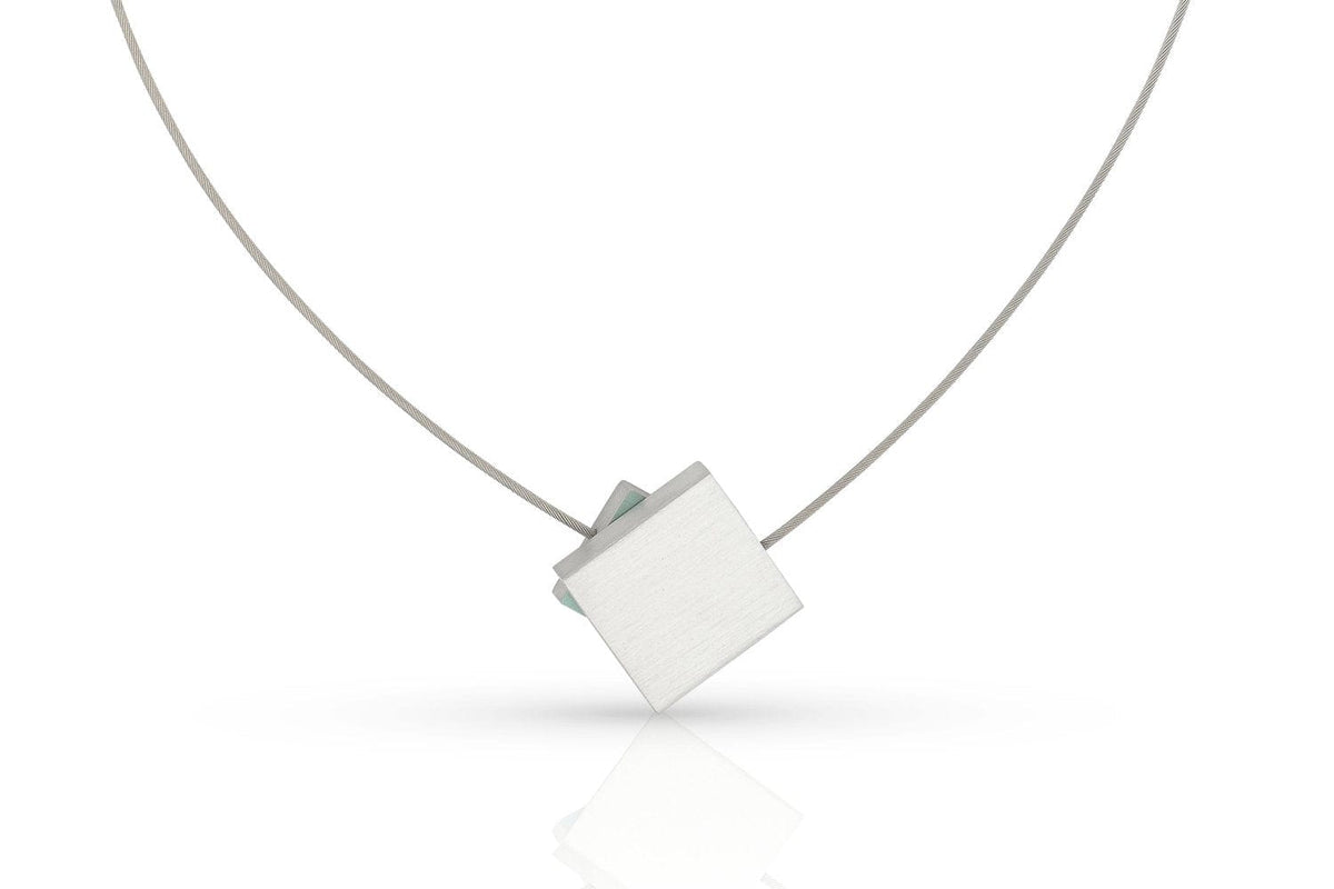De CLIC Creations Collier Vierkant met gekleurd vierkant C263B heeft een minimalistisch design met een dun zilverkleurig draadje en een geometrische, vierkante hanger die schuin hangt, afgewerkt met een strakke magneetsluiting voor eenvoudig dragen.