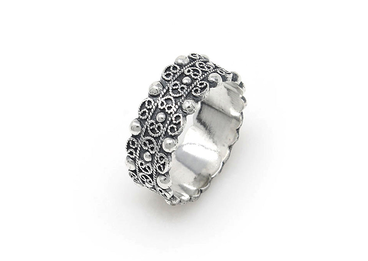 Ring aus Silber mit Ziermuster und kleinen Kugeln, breiter Band mit strukturierter Oberfläche