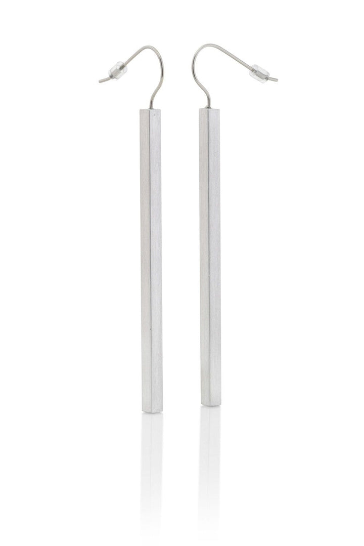 De Oorhanger lange staafjes O38 van CLIC Creations zijn minimalistische, handgemaakte aluminium oorhangers uit Nederland. Strak zilver met dunne haken en lange verticale staven, ze stralen moderne verfijning uit tegen een witte achtergrond.
