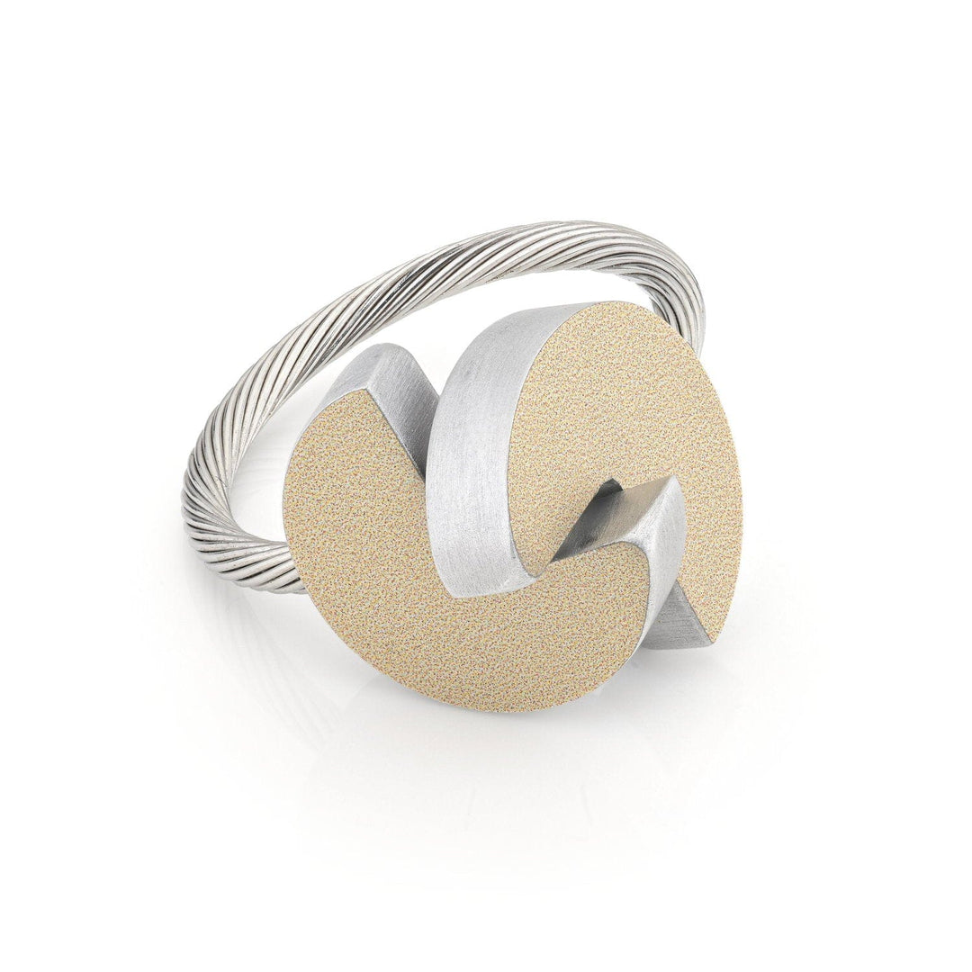 De R12G zilveren ring van Clic Creations toont een ingewikkeld ontwerp met een gedraaide band. Het opvallende kenmerk is een modern, artistiek middelpunt dat in elkaar grijpende matte gouden en zilverkleurige abstracte vormen combineert.