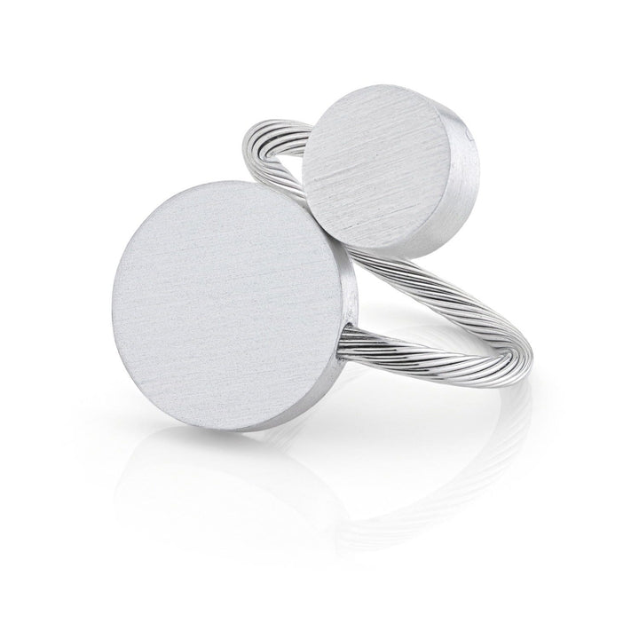 De Ring Twee ronde vormen R5 van CLIC Creations is een zilveren ring die met de hand is gemaakt in Nederland, met twee unieke, ronde platte schijven van verschillende groottes. De grotere schijf staat centraal met een kleinere erboven, aangevuld met een getextureerde gedraaide band voor een moderne minimalistische look.