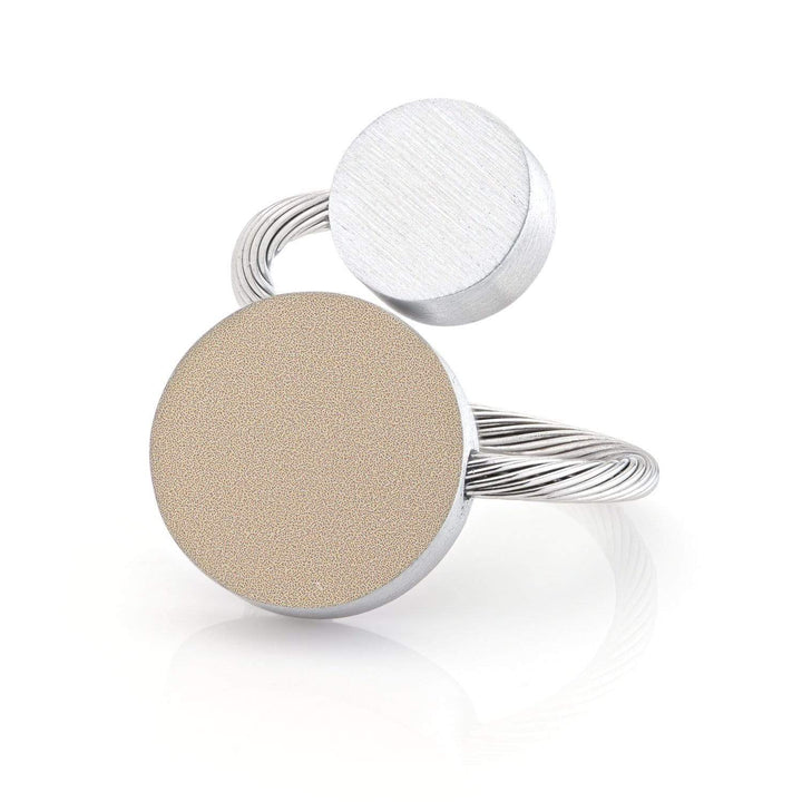 De Ring Twee ronde vormen Goud|Zand R5G van CLIC Creations heeft twee ronde schijven, één met textuur en één glad, verbonden door een gedraaide band. Het artistieke ontwerp plaatst de schijven in verschillende hoeken. Handgemaakt in Nederland voor originaliteit.