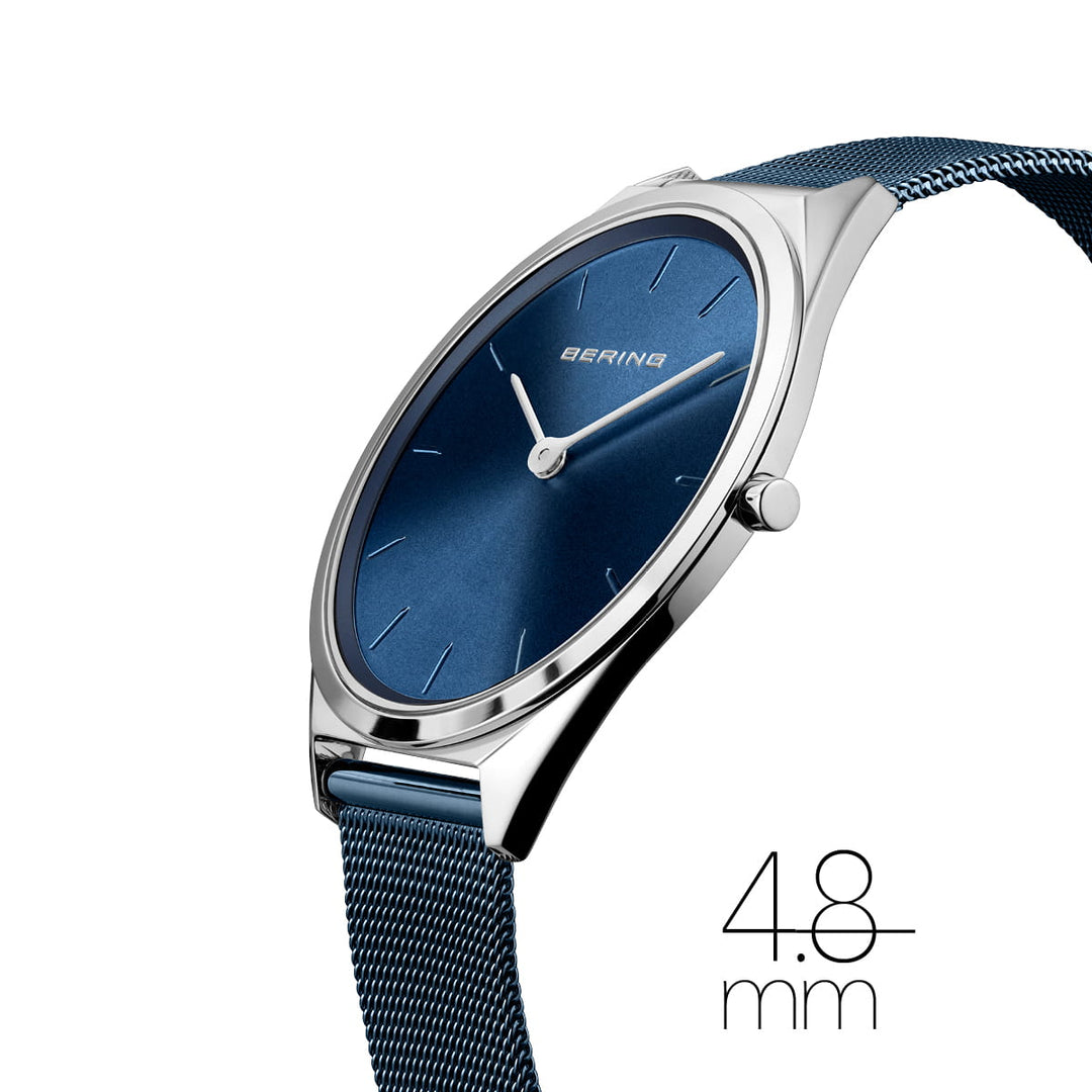Zijaanzicht van het Bering Unisex Horloge (17039-307) met een blauwe wijzerplaat en zilveren kast, met minimalistische uurmarkeringen, saffierglas en een blauwe mesh-band. 4,8 mm geeft aan dat het een ultradun ontwerp is met een quartz-uurwerk.