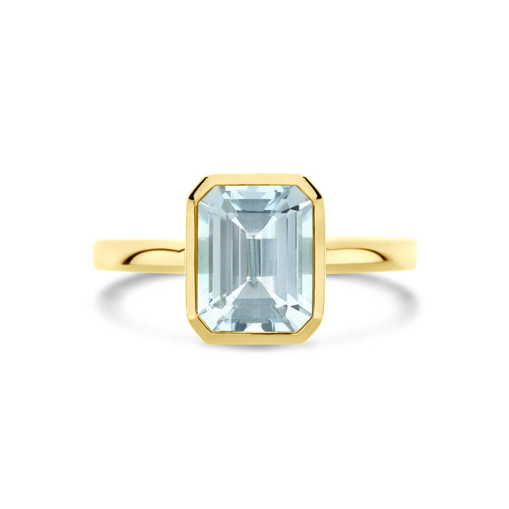 De ring aquamarijn 14K geelgoud van Van der Kooij Collectie heeft een rechthoekige, smaragdgeslepen aquamarijn in een strakke bezelzetting, tegen een witte achtergrond.