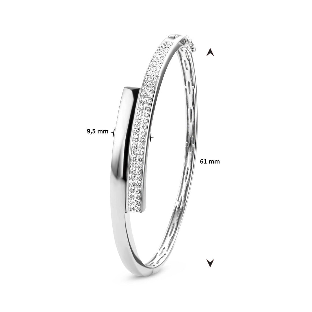 De Van der Kooij Collectie bangle zirkonia 9,5 x 61 mm is een zilver gerhodineerd damesarmband met een rij fonkelende zirkonia en elegante afmetingen van 9,5 mm breed en 61 mm diameter.